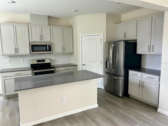 a kitchen with a refrigerator and a stove