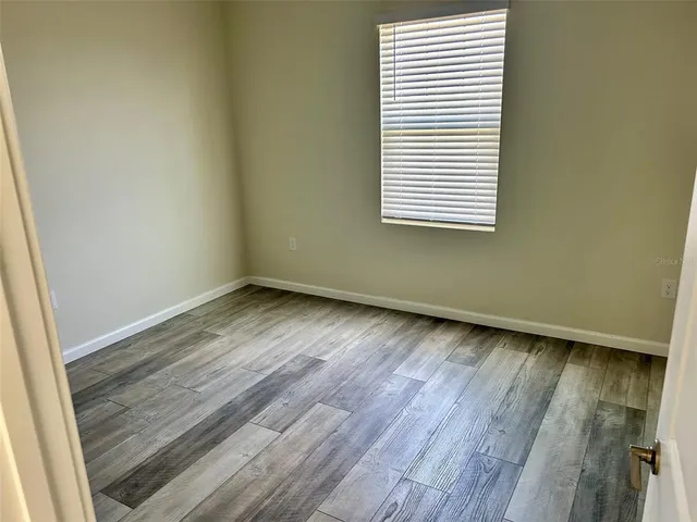 an empty room with wooden floor and a window