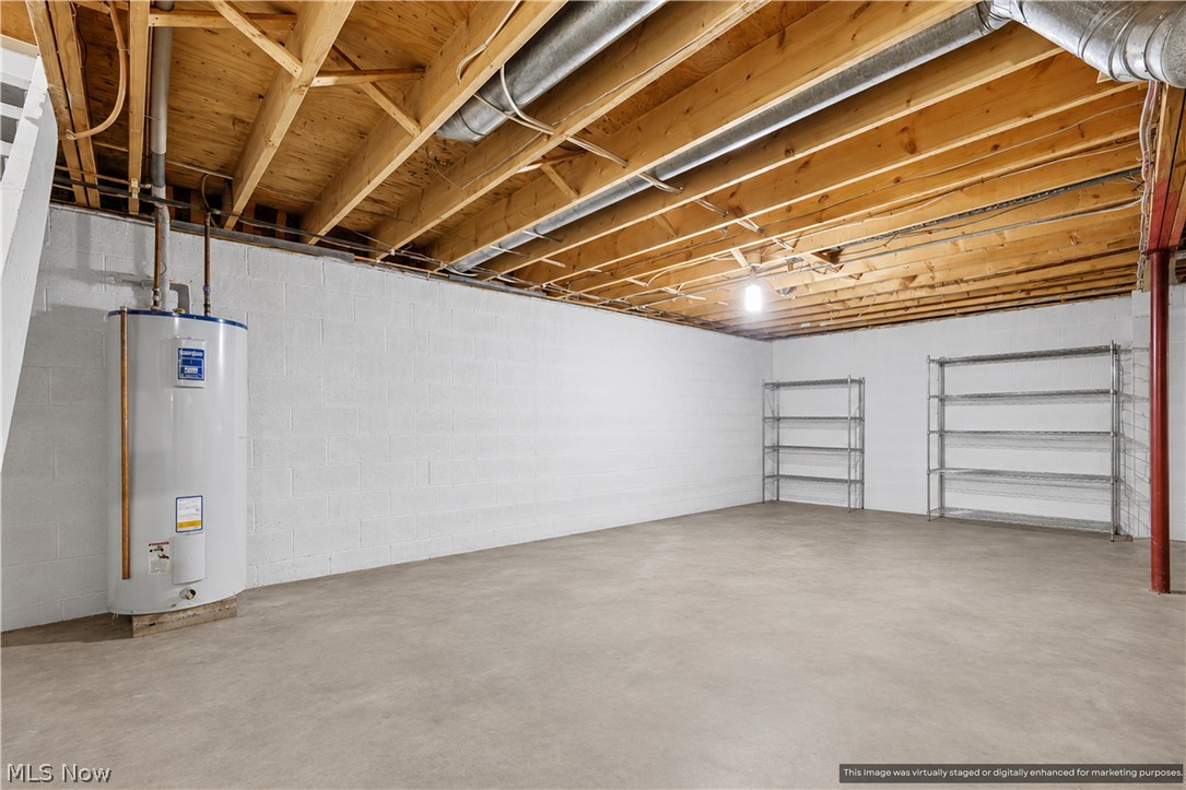 1835 Lynn Road Kent, OH 44240 - Photo 41 of 48 Unfinished basement featuring concrete flooring, painted block walls, exposed wood ceiling joists, and a water heater