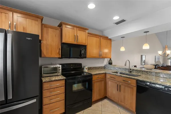 a kitchen with stainless steel appliances granite countertop a stove a sink and a refrigerator