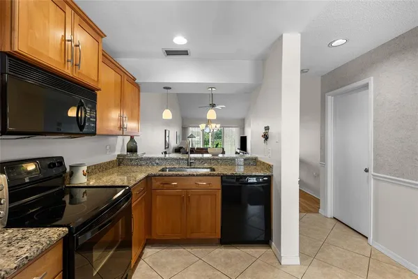 a kitchen with a sink and a stove top oven with wooden floor