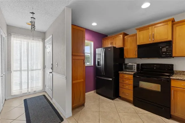 a kitchen with stainless steel appliances granite countertop a refrigerator and a stove top oven