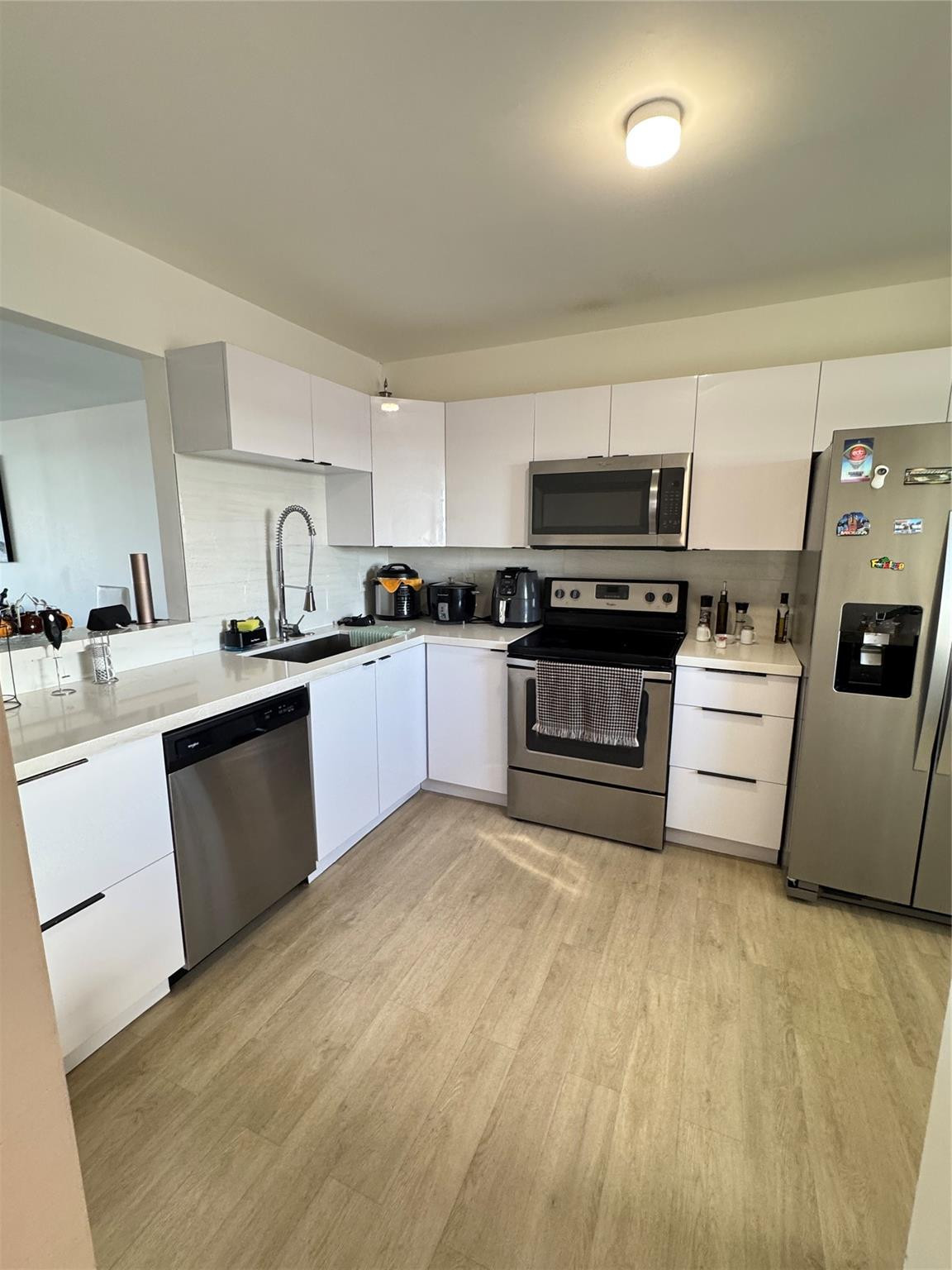 1770 Northeast 191st Street, Unit 816 Miami, FL 33179 - Photo 1 of 33 a kitchen with a sink a stove and cabinets