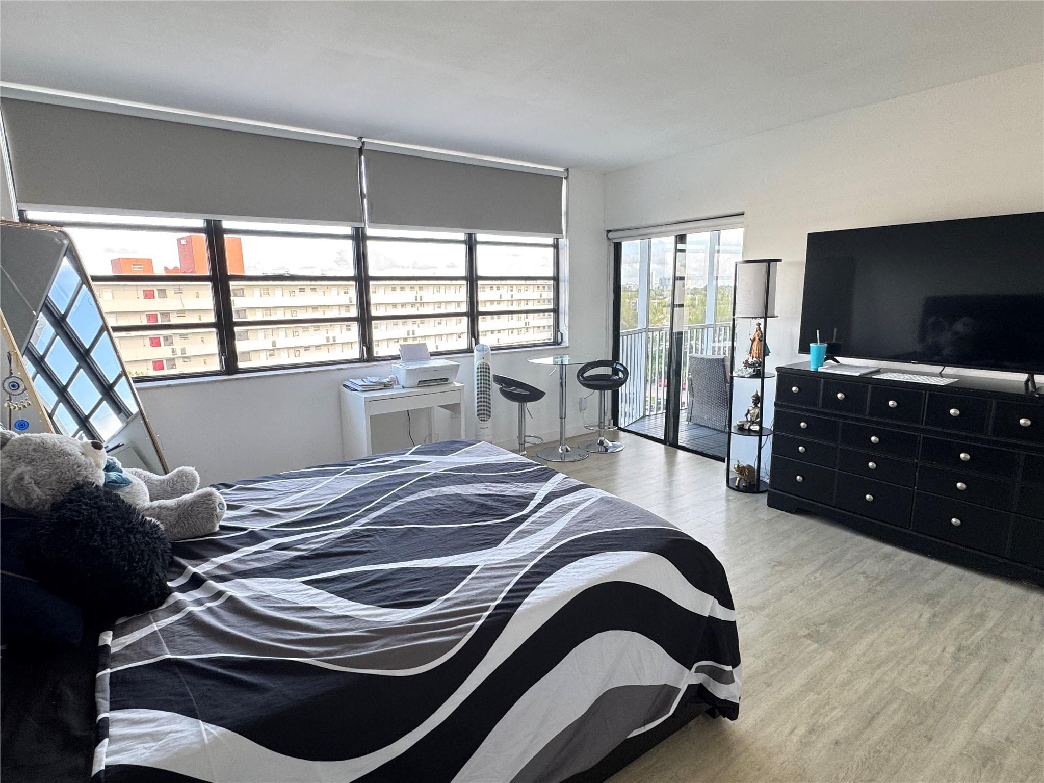 1770 Northeast 191st Street, Unit 816 Miami, FL 33179 - Photo 21 of 33 a bedroom with a bed and a flat tv screen on dresser