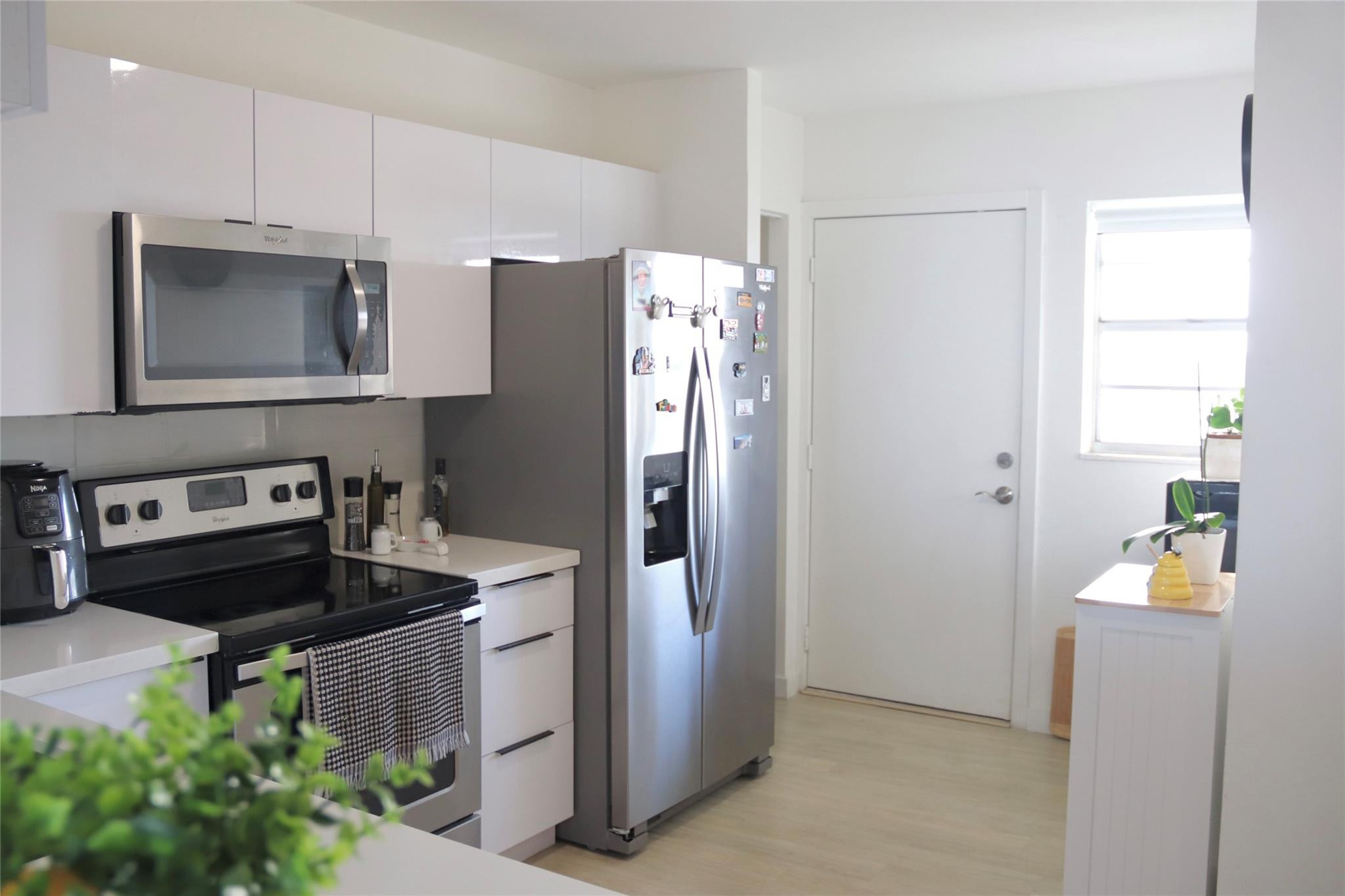 1770 Northeast 191st Street, Unit 816 Miami, FL 33179 - Photo 3 of 33 a kitchen with stainless steel appliances granite countertop a refrigerator and a stove