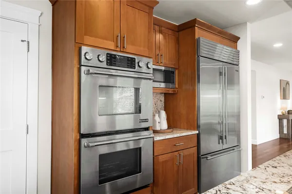 a kitchen with stainless steel appliances granite countertop a refrigerator stove and cabinets