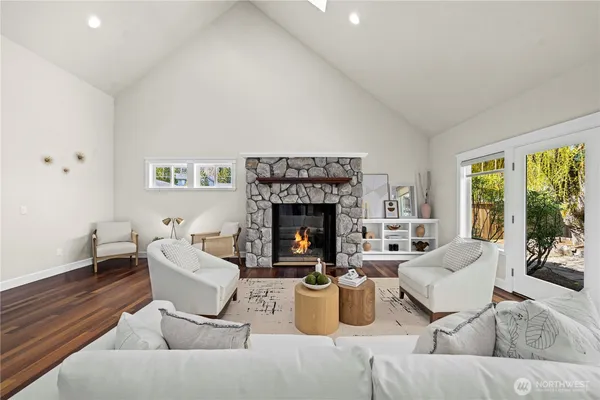 a living room with furniture a fireplace and a large window