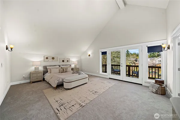 a spacious bedroom with a bed couch and a large window
