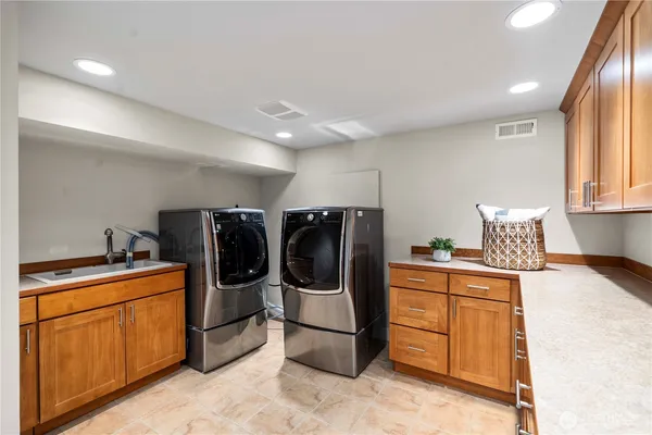 a utility room with sink dryer and washer