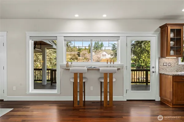 a view of a livingroom with furniture wooden floor a fireplace and windows