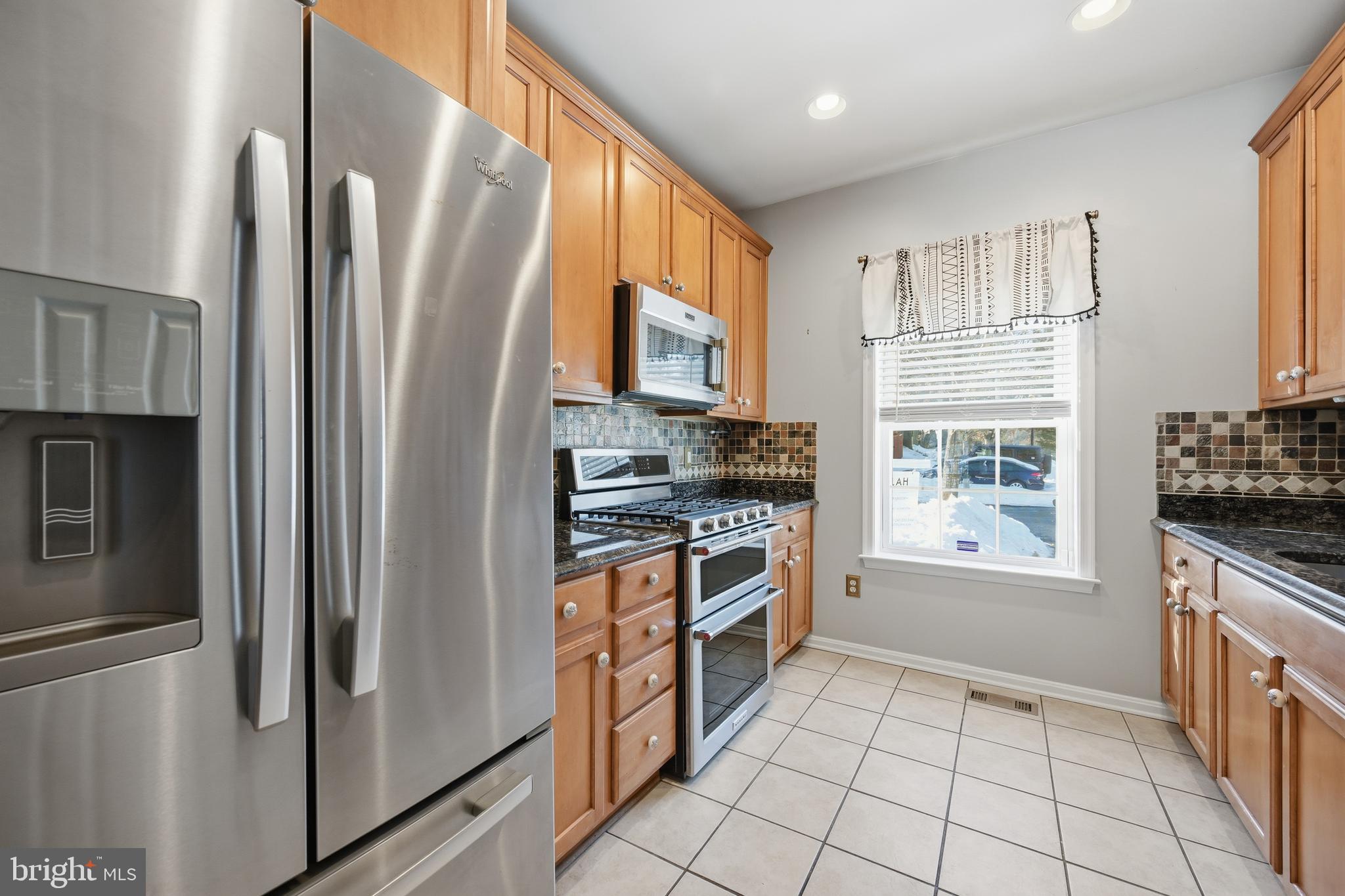 18733 Falling River Drive Gaithersburg, MD 20879 - Photo 6 of 34 a kitchen with stainless steel appliances granite countertop a refrigerator a stove and a sink