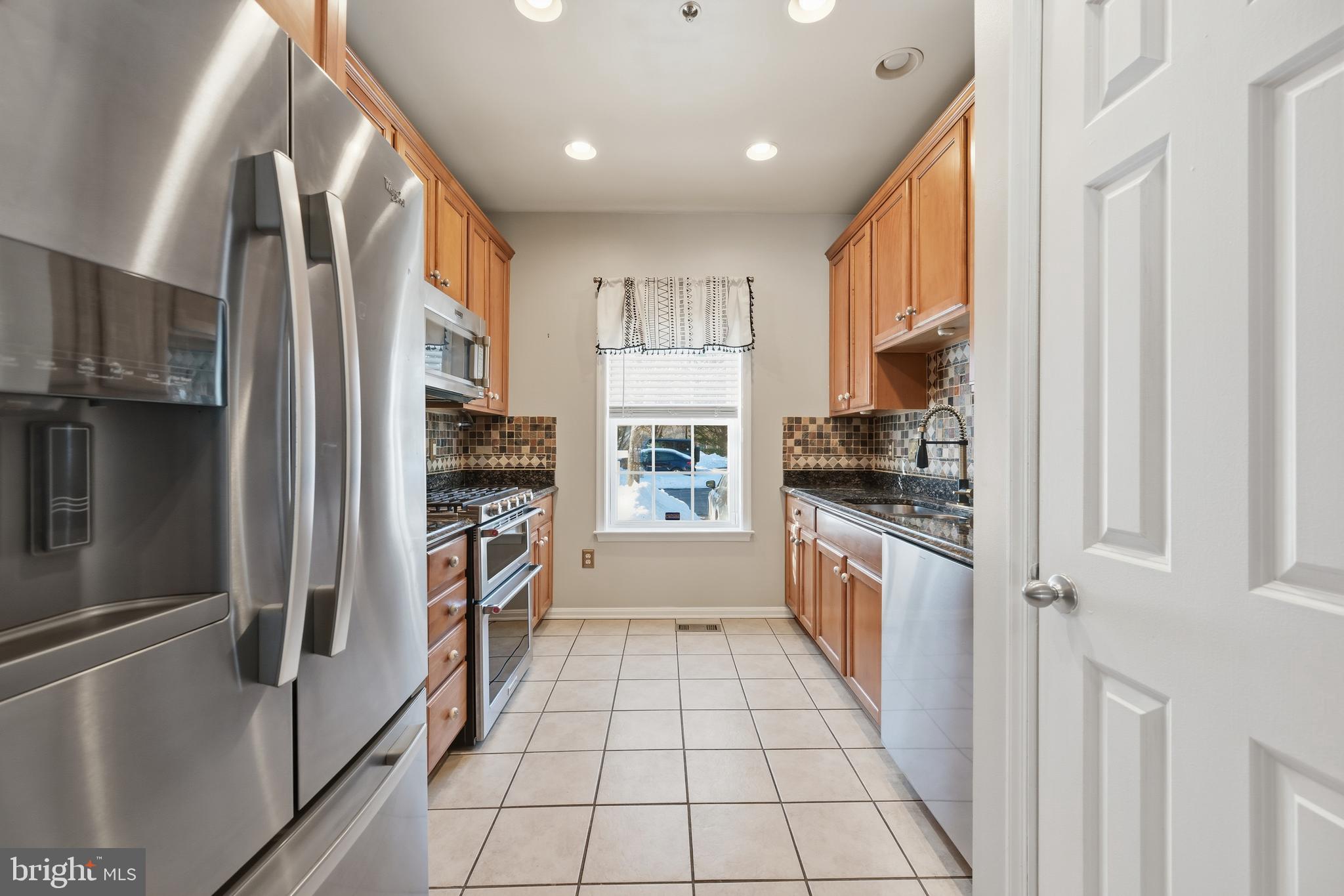 18733 Falling River Drive Gaithersburg, MD 20879 - Photo 7 of 34 a kitchen with a refrigerator a sink and a stove top oven