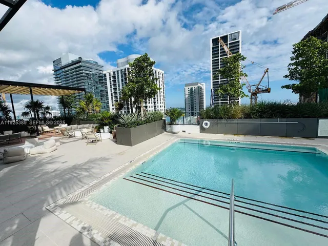 a swimming pool with outdoor seating and yard