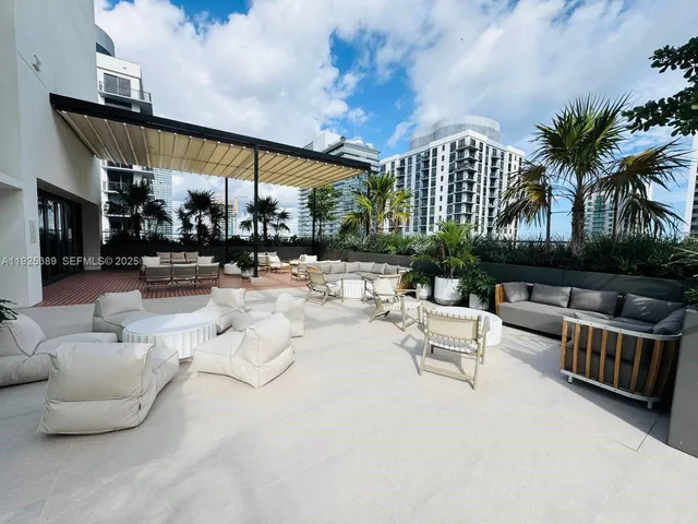 a building outdoor space with patio furniture and potted plants