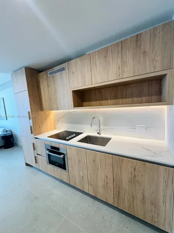 a kitchen with stainless steel appliances a stove a sink and a microwave
