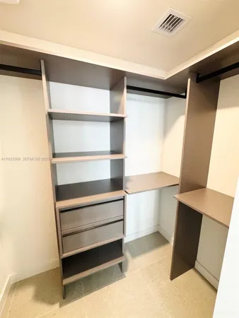 a view of walk in closet with empty racks