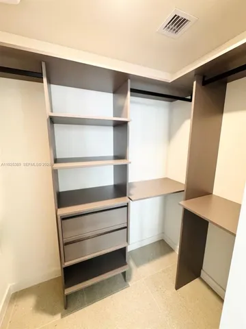 a view of walk in closet with empty racks