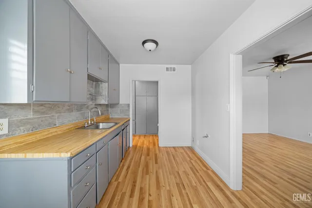 a view of a kitchen with a sink and wooden floor