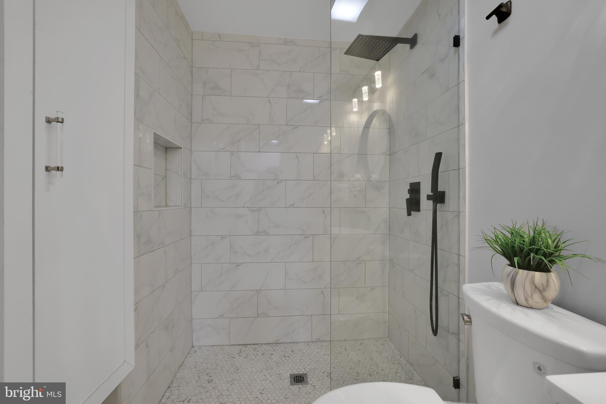 15101 Snowden Drive Silver Spring, MD 20905 - Photo 24 of 68 a bathroom with a shower a toilet a sink and mirror