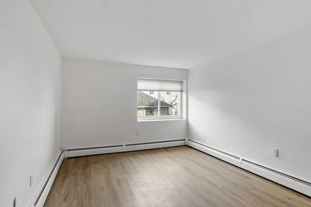 a view of a room with wooden floor and window
