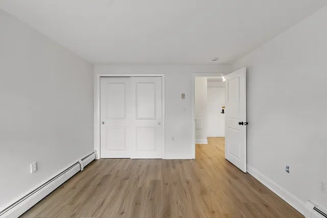 a view of an empty room with wooden floor