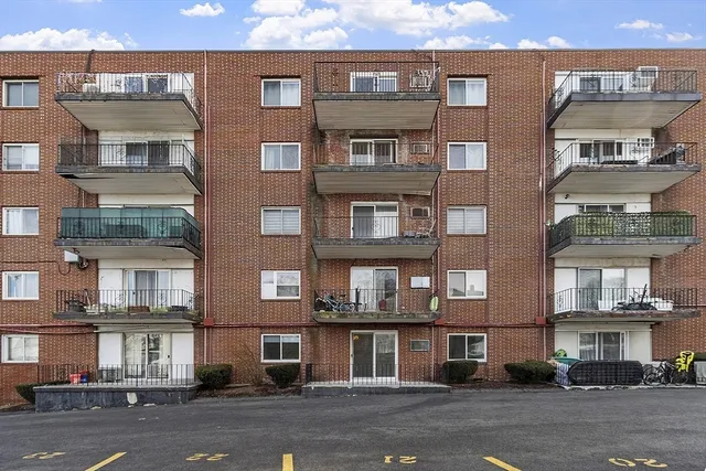 a view of a building and a cars parked on the side of road