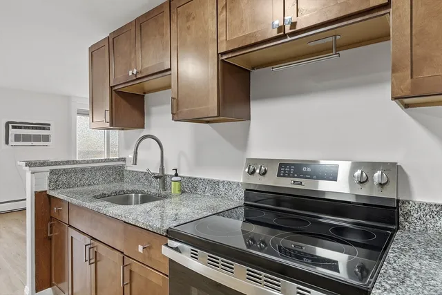 a kitchen with granite countertop a stove and a sink
