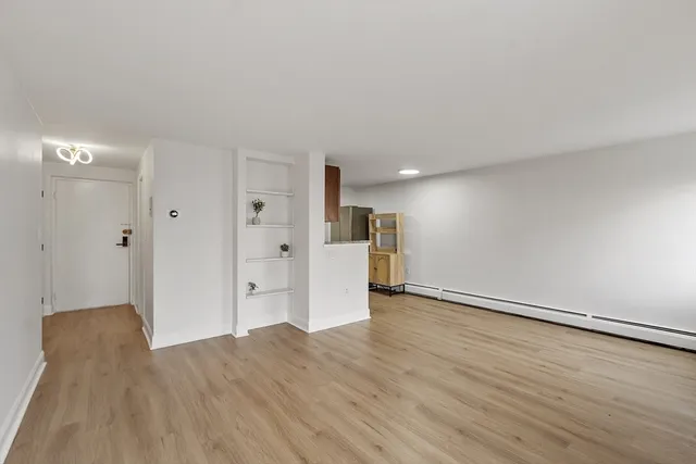 a view of an empty room with wooden floor