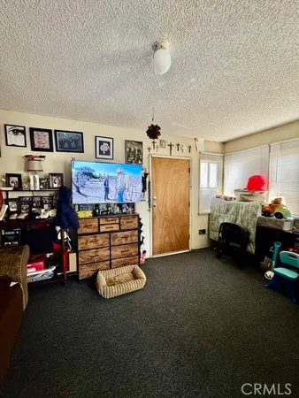 a living room with furniture a rug and kitchen view