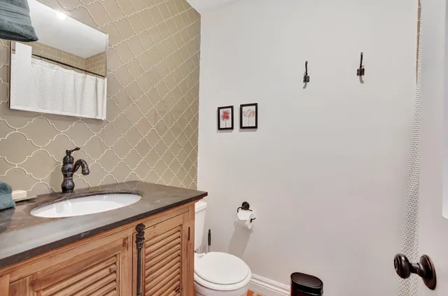 a bathroom with a sink vanity mirror and toilet