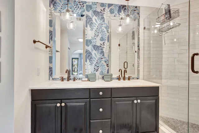 a bathroom with a sink vanity granite shower and a mirror