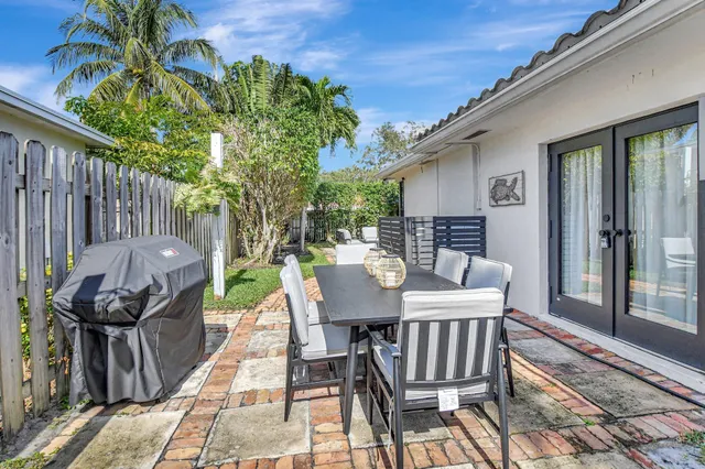 a view of a patio with table and chairs with wooden floor and fence