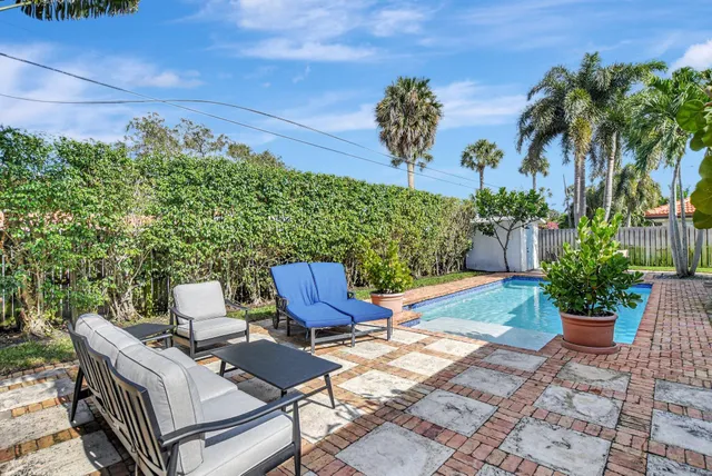 a view of a house with backyard and sitting area