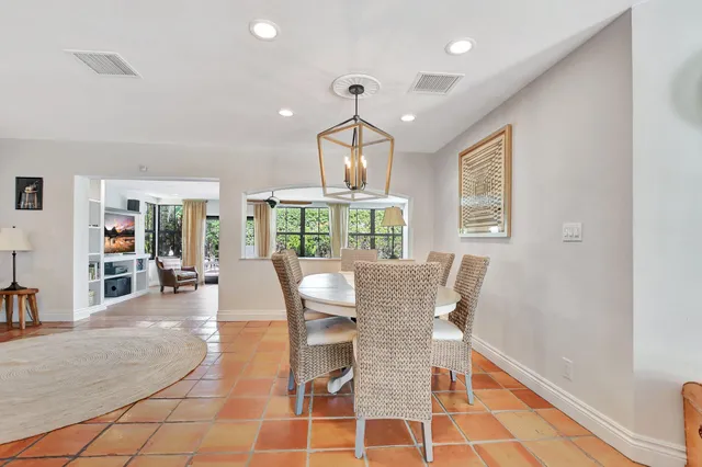a dining room with furniture a chandelier and wooden floor