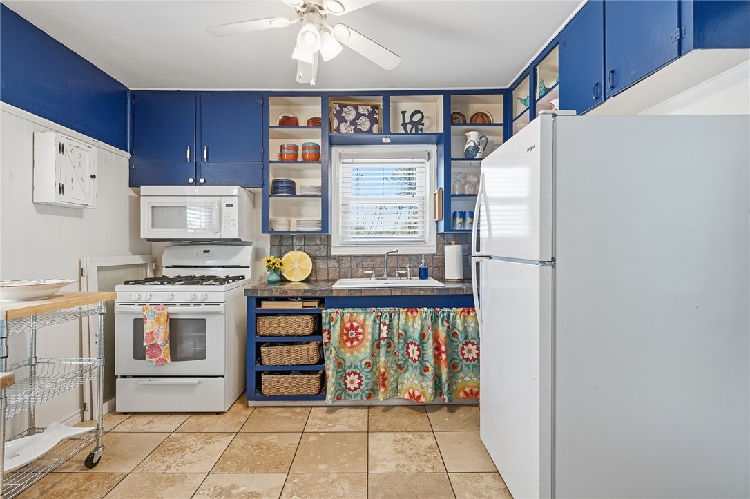 607 Chaparral Street Fulton, TX 78382 - Photo 11 of 40 a kitchen with stainless steel appliances a refrigerator and a stove top oven