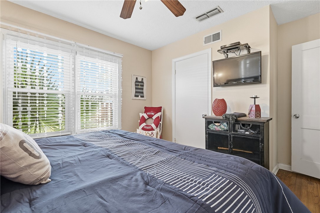 607 Chaparral Street Fulton, TX 78382 - Photo 20 of 40 a bedroom with a bed and wooden floor