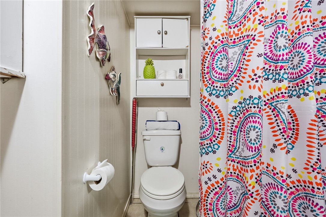 607 Chaparral Street Fulton, TX 78382 - Photo 22 of 40 a white toilet sitting next to a shower curtain