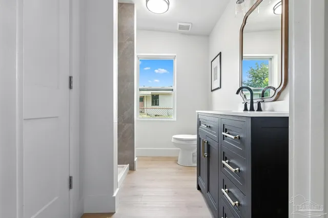 a bathroom with a sink a toilet and a mirror
