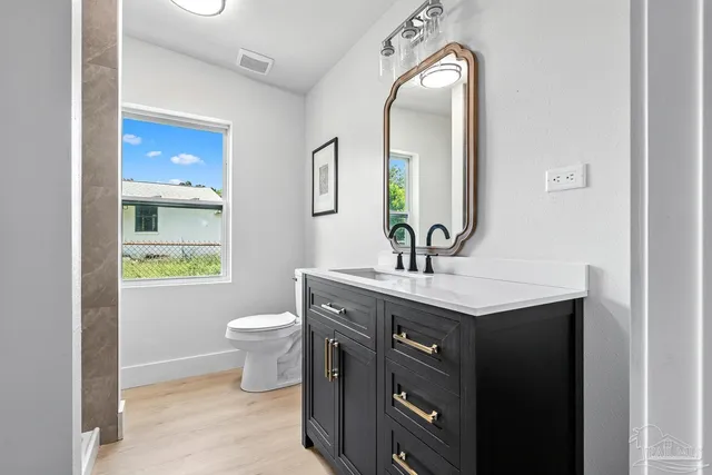 a bathroom with a toilet a sink and mirror