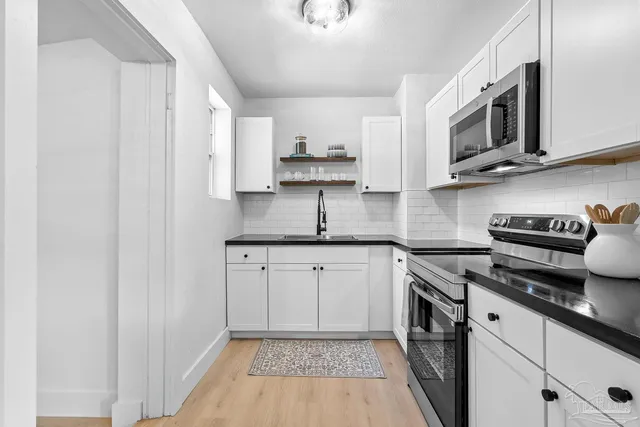 a kitchen with stainless steel appliances granite countertop a sink and a stove top oven