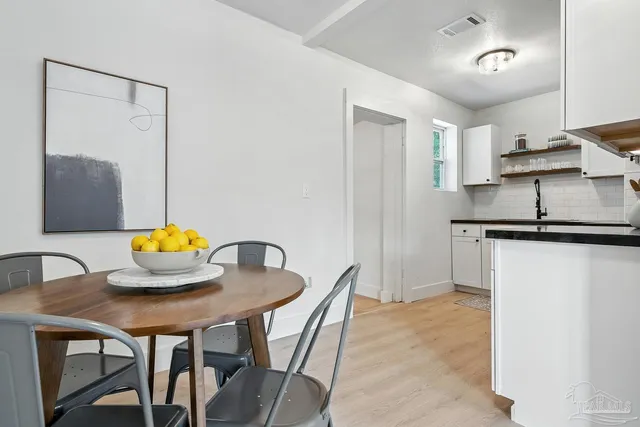 a kitchen with stainless steel appliances kitchen island granite countertop a table and a chair