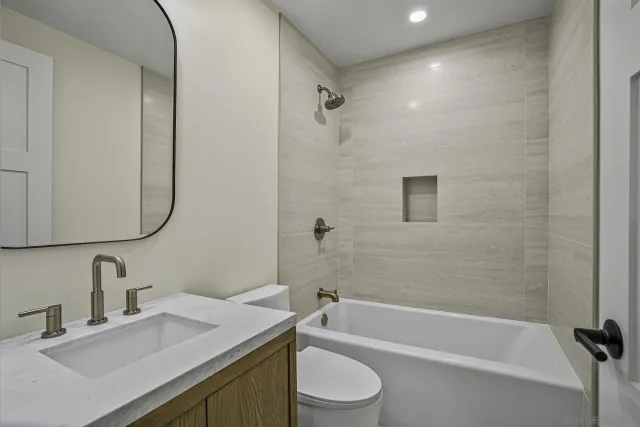 a bathroom with a granite countertop sink toilet and shower