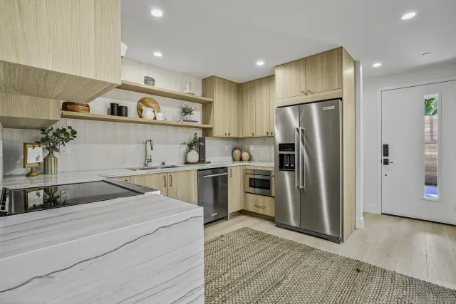 a kitchen with a sink stainless steel appliances and refrigerator