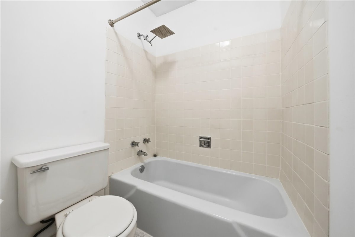 33 North Main Street, Unit 2E Lombard, IL 60148 - Photo 10 of 16 a white toilet sitting next to a bath tub