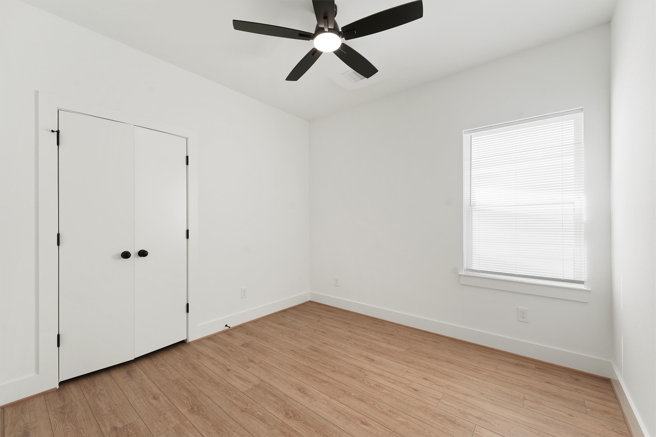 407 Calloway Street, Unit AB Houston, TX 77029 - Photo 4 of 19 an empty room with wooden floor ceiling fan and windows