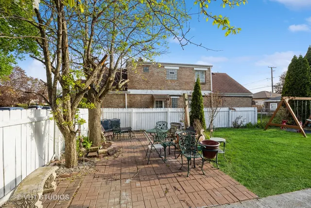 a view of a house with backyard sitting area and garden