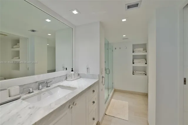 a bathroom with a granite countertop sink a shower and a mirror