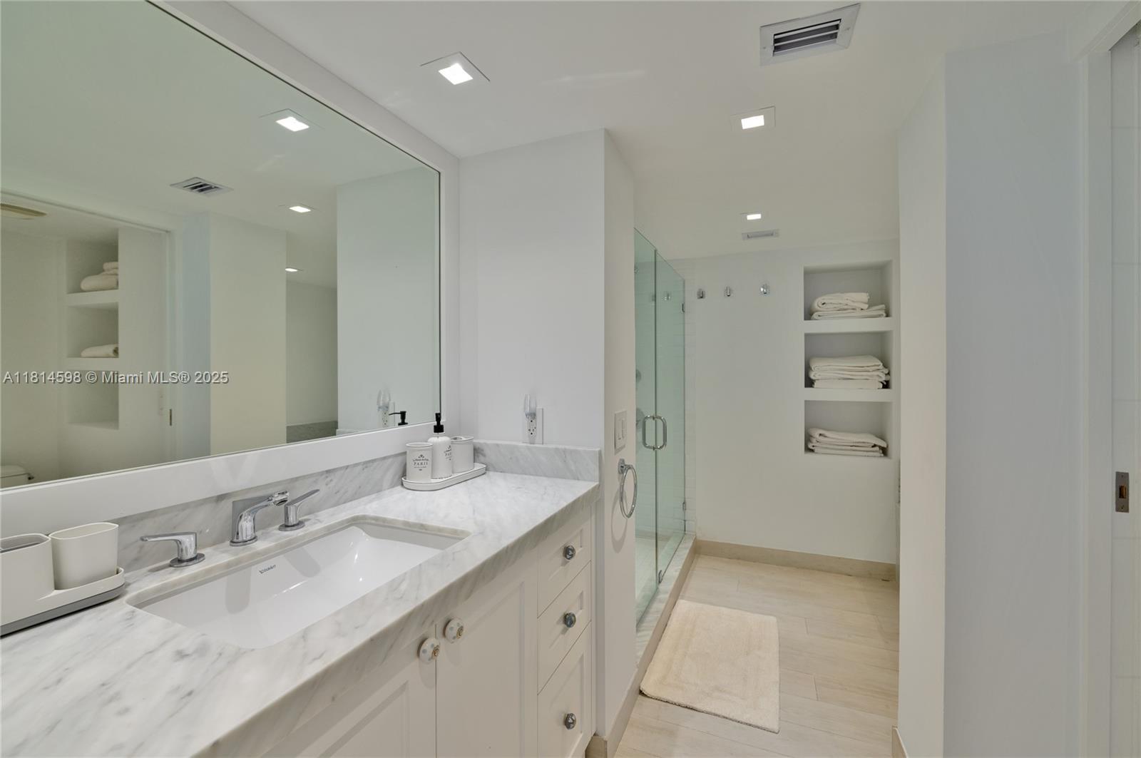 101 Crandon Boulevard, Unit 480 Key Biscayne, FL 33149 - Photo 16 of 28 a bathroom with a granite countertop sink a shower and a mirror
