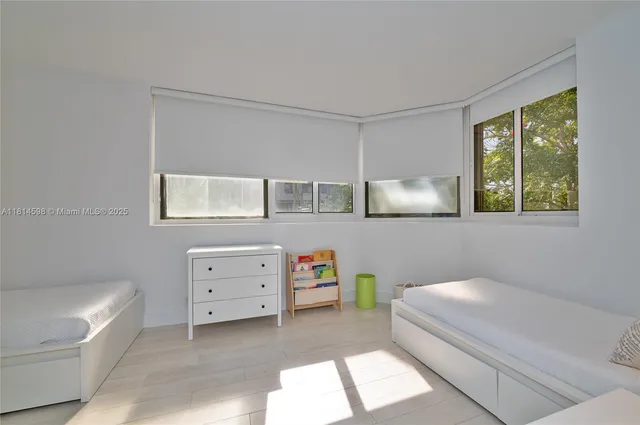 a room with a baby bed baby crib and a dresser