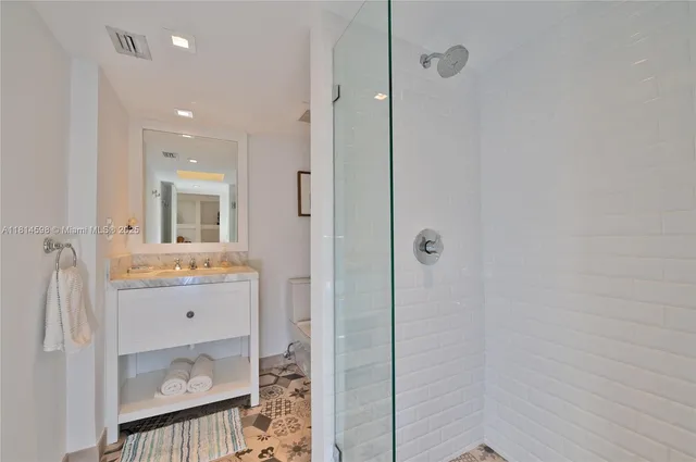 a bathroom with a granite countertop sink a toilet and shower